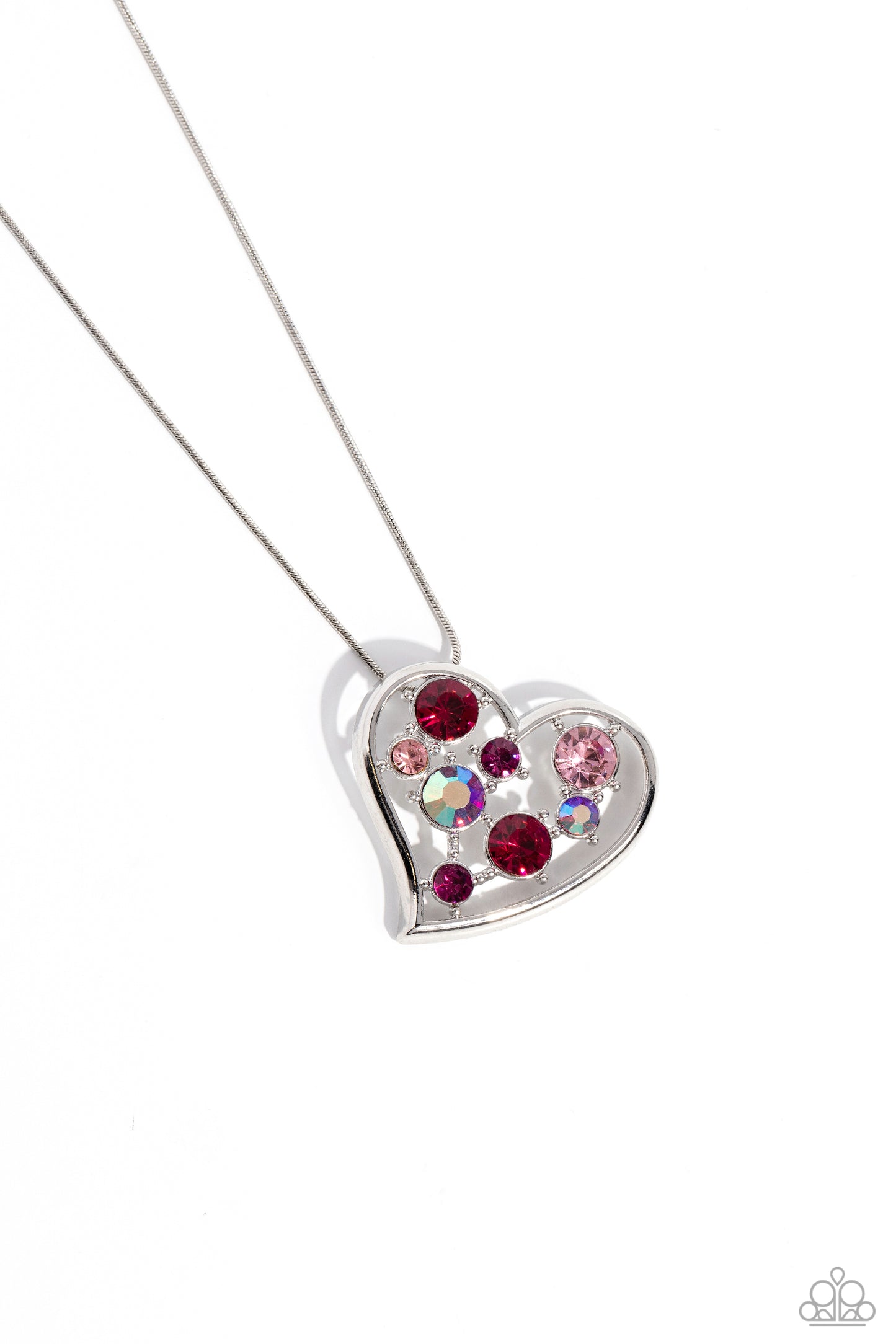 Romantic Recognition Pink Rhinestone Heart Necklace - Paparazzi Accessories  Cascading from a silver snake chain, a thick, sideways sliding-heart silhouette falls down the neckline for a romantic statement. Haphazardly scattered across the inside of the heart frame, a glittery collection of pink and iridescent fuchsia round rhinestones in varying sizes shimmer and shine for a refined finish. Features an adjustable clasp closure. Due to its prismatic palette, color may vary.