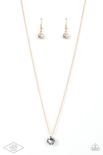 What A Gem Gold Necklace - Paparazzi Accessories  A single rhinestone sparkles brilliantly at the bottom of a dainty gold chain, creating a stunning solitaire design. Features an adjustable clasp closure.  Sold as one individual necklace. Includes one pair of matching earrings. This Fan Favorite is back in the spotlight at the request of our 2021 Life of the Party member with Black Diamond Access, Betsy M.