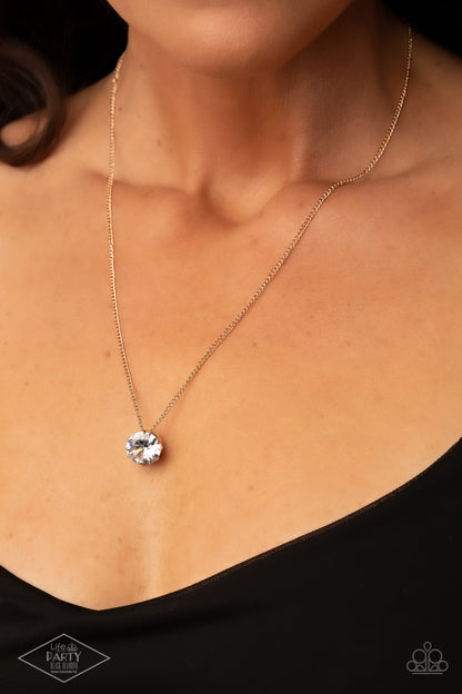 What A Gem Gold Necklace - Paparazzi Accessories  A single rhinestone sparkles brilliantly at the bottom of a dainty gold chain, creating a stunning solitaire design. Features an adjustable clasp closure.  Sold as one individual necklace. Includes one pair of matching earrings. This Fan Favorite is back in the spotlight at the request of our 2021 Life of the Party member with Black Diamond Access, Betsy M.