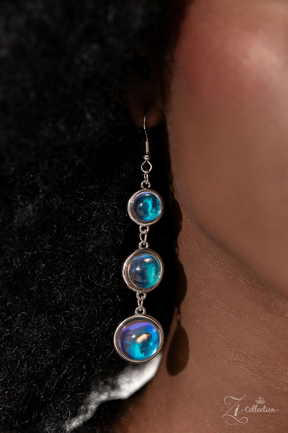 Hypnotic Multi 2023 Zi Collection Necklace - Paparazzi Accessories  A dizzying display of silver hoops drapes across the chest in effervescent layers. Smooth, glassy beads, brushed in swirls of pastel iridescence, bubble up from some of the open, circular frames, further exaggerating their staggered size and placement, and showcasing their dreamy opalescent finish. With every new angle, a different hue emerges from the glassy beads.