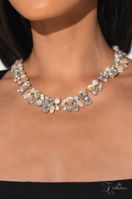 Enchanting Gold 2023 Zi Collection Necklace - Paparazzi Accessories  A treasure trove of textures and sheen emerges along the neckline, as a collection of beads, gems, and pearls group into haphazard clusters. From iridescent teardrops to glowing cat’s eyes, emerald-cut rhinestones to gold-flecked acrylics, new details emerge at every angle. Pronged fittings adorn each individual bead, adding hints of metallic sheen while emphasizing the design’s handcrafted character and vintage refinement. 