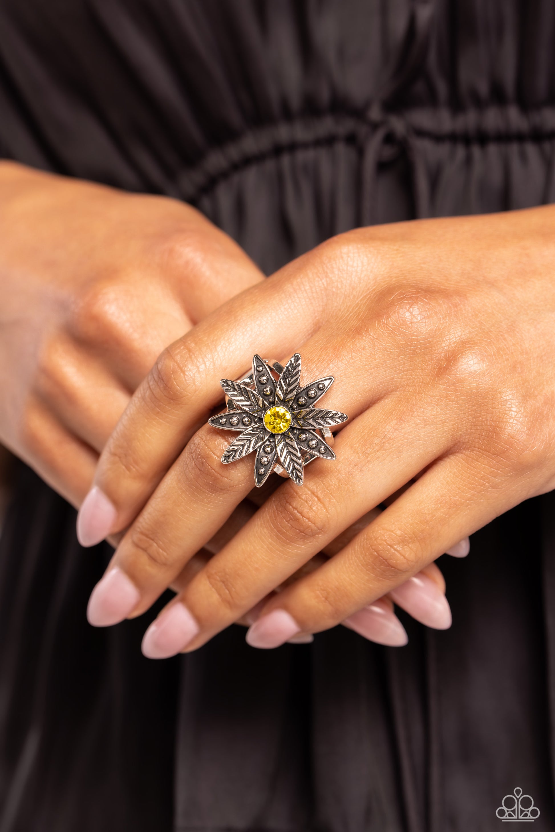 Sunflower Season Yellow Flower Ring - Paparazzi Accessories  Unfurling around a yellow gem center, textured and studded silver petals alternate atop airy silver bands on the finger for a whimsically botanical centerpiece. Features a stretchy band for a flexible fit.  Sold as one individual ring.  Sku:  P4WH-YWXX-157XX