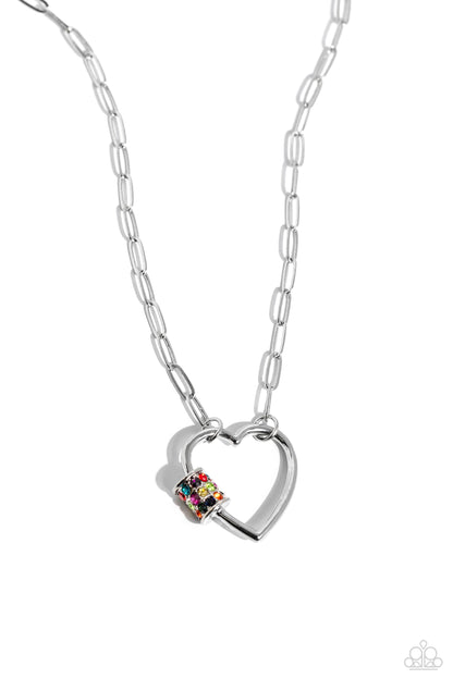 Affectionate Attitude Multi Heart Necklace - Paparazzi Accessories  A sleek silver heart sits at the center of a silver paperclip chain, resulting in a romantically monochromatic design. A thick silver carabiner accent, encrusted in multicolored rhinestones, rests along one of the heart's curves for an explosion of vivacious color to the design. Features an adjustable clasp closure.  Sold as one individual necklace. Includes one pair of matching earrings.  P2RE-MTXX-226XX