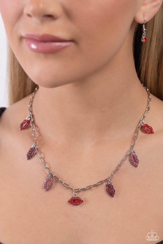 KISS the Mark Red Necklace - Paparazzi Accessories  Set along a silver paperclip chain, a pouty collection of lip charms, each embossed in red, dark red, and pink rhinestones alternates below the collar for a love-struck fashion. Features an adjustable clasp closure.  Sold as one individual necklace. Includes one pair of matching earrings.  P2WH-RDXX-336XX