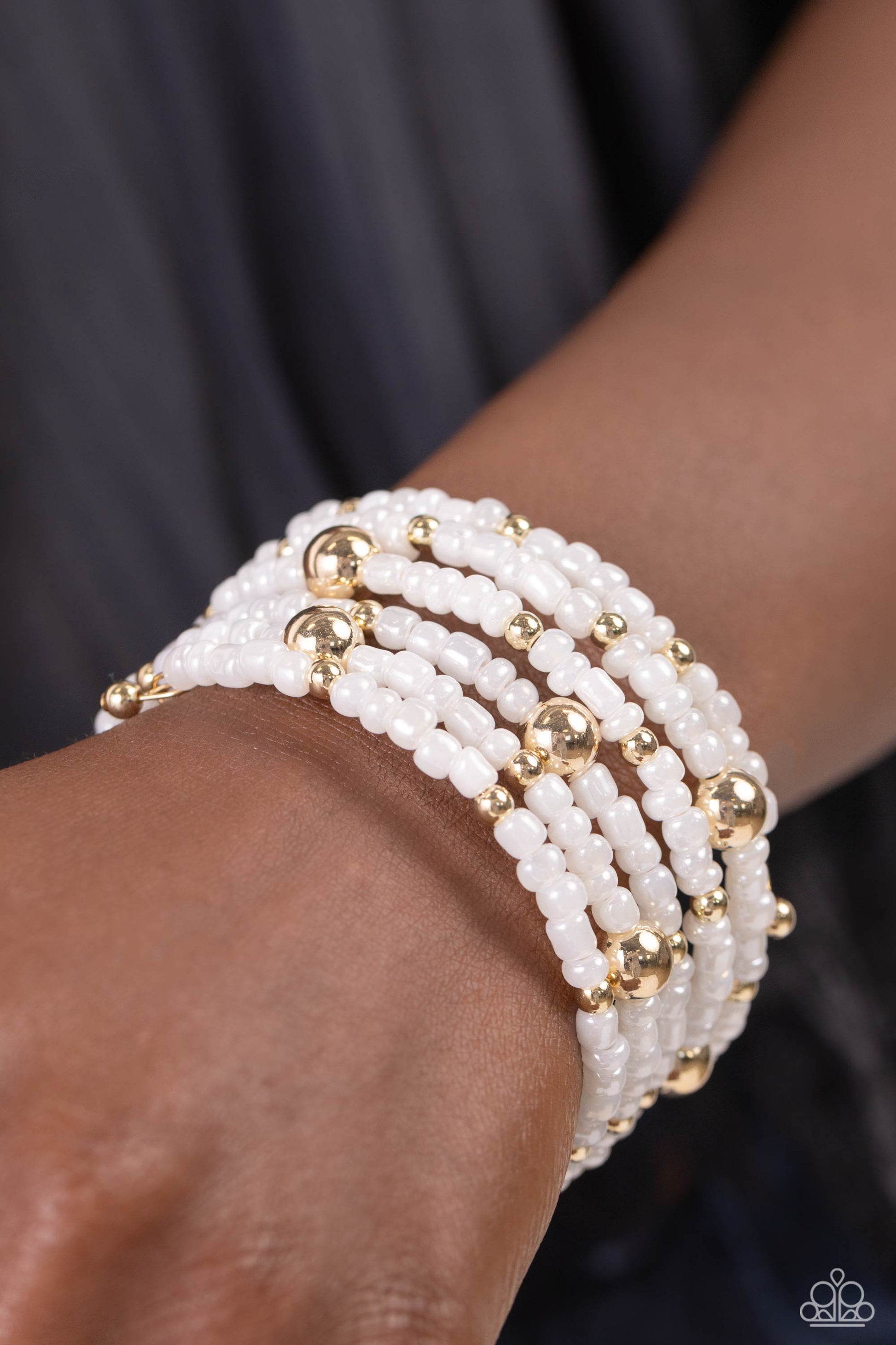 Refined Retrograde Gold Coil Bracelet - Paparazzi Accessories  Pearly white seed beads, and various-sized gold accents are threaded along a coiled wire, creating a refined infinity wrap-style bracelet around the wrist.  Sold as one individual bracelet.  P9RE-GDXX-401XX