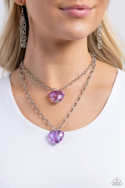 Layered Love Purple Heart Necklace - Paparazzi Accessories  Featuring a subtle iridescent shimmer, two glassy purple gem hearts are delicately suspended above one another on a paperclip and silver oval link chain for a whimsical double-stacked display. Features an adjustable clasp closure.  Sold as one individual necklace. Includes one pair of matching earrings.  SKU: P2WH-PRXX-446XX