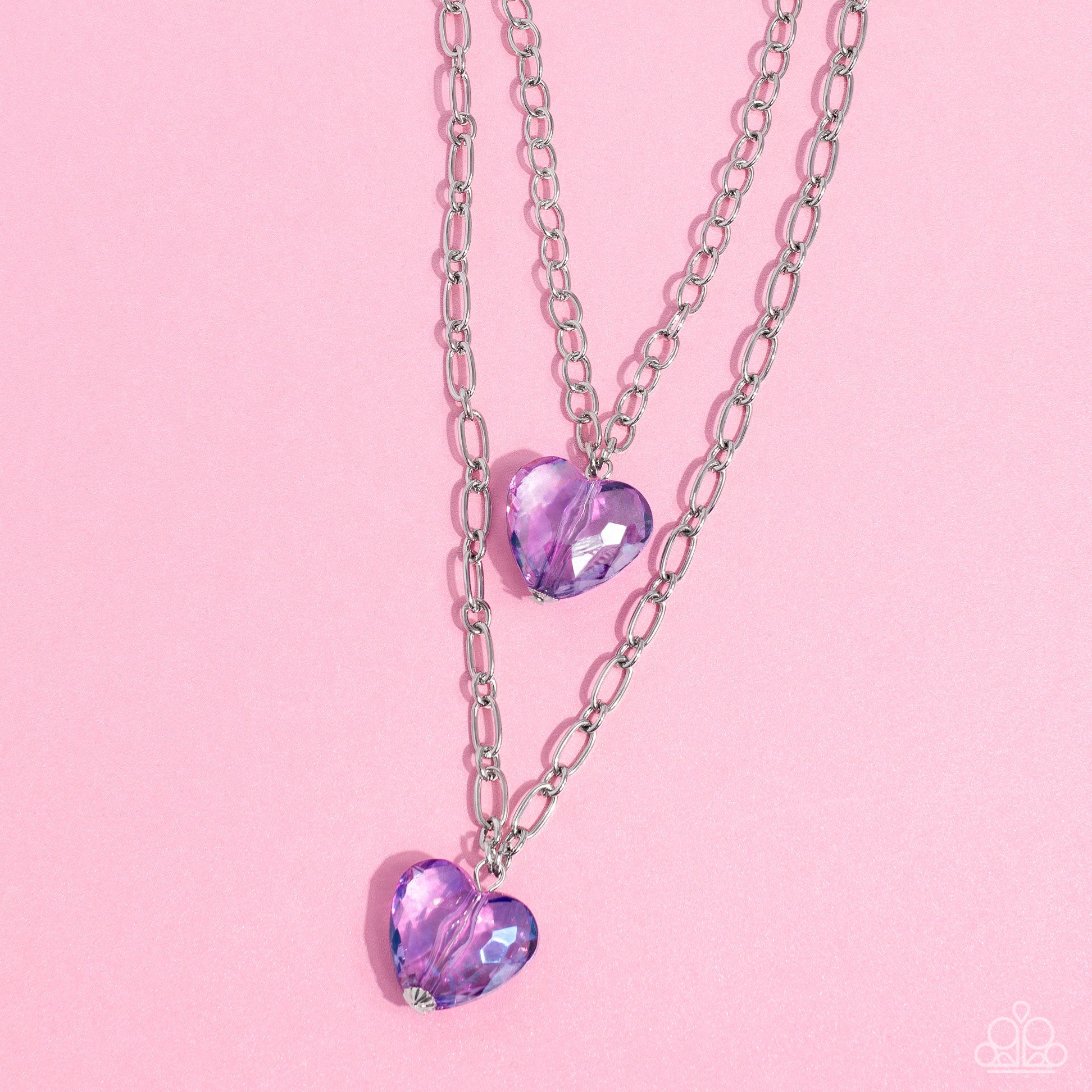 Layered Love Purple Heart Necklace - Paparazzi Accessories  Featuring a subtle iridescent shimmer, two glassy purple gem hearts are delicately suspended above one another on a paperclip and silver oval link chain for a whimsical double-stacked display. Features an adjustable clasp closure.  Sold as one individual necklace. Includes one pair of matching earrings.  SKU: P2WH-PRXX-446XX