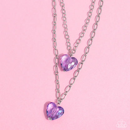 Layered Love Purple Heart Necklace - Paparazzi Accessories  Featuring a subtle iridescent shimmer, two glassy purple gem hearts are delicately suspended above one another on a paperclip and silver oval link chain for a whimsical double-stacked display. Features an adjustable clasp closure.  Sold as one individual necklace. Includes one pair of matching earrings.  SKU: P2WH-PRXX-446XX