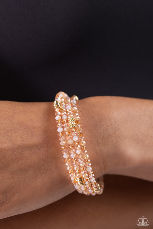 Dreamy Debut Gold Infinity Wrap Coil Bracelet - Paparazzi Accessories  Sections of clear, champagne, and gold beads are threaded along the wrist in an infinity wrap-style bracelet for a dreamy statement.  Sold as one individual bracelet.  P9RE-GDXX-402XX