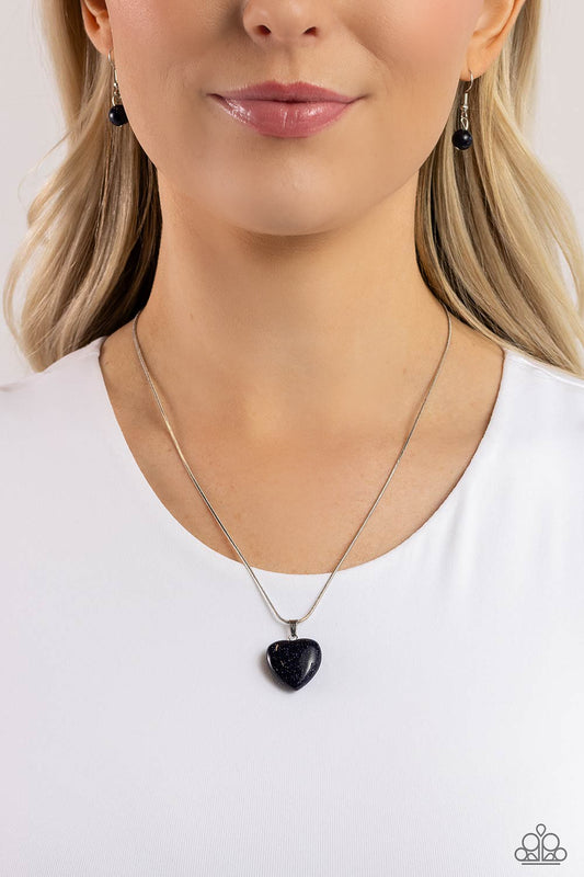 Prismatic Pastime Blue Heart Necklace - Paparazzi Accessories  Brushed in a glittery finish, a dark blue heart dangles at the bottom of a lengthened silver snake chain, creating a glittery pendant. Features an adjustable clasp closure.  Sold as one individual necklace. Includes one pair of matching earrings.  P2DA-BLXX-195XX