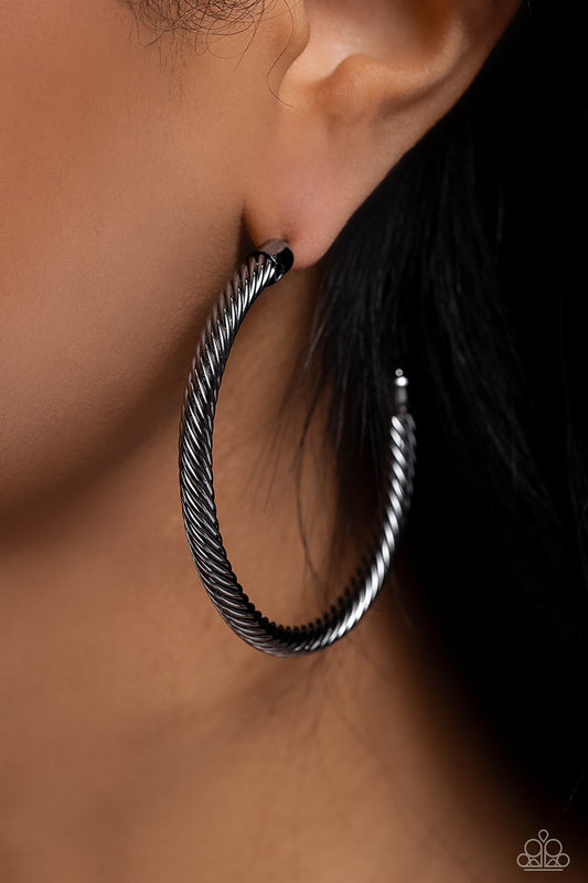 Roped in Radiance Black Hoop Earring - Paparazzi Accessories  Shimmering gunmetal spins into an oversized twisted rope as it curves into a classic thick hoop design. Earring attaches to a standard post fitting. Hoop measures approximately 2" in diameter.  Sold as one pair of hoop earrings.  Sku:  P5HO-BKXX-270XX