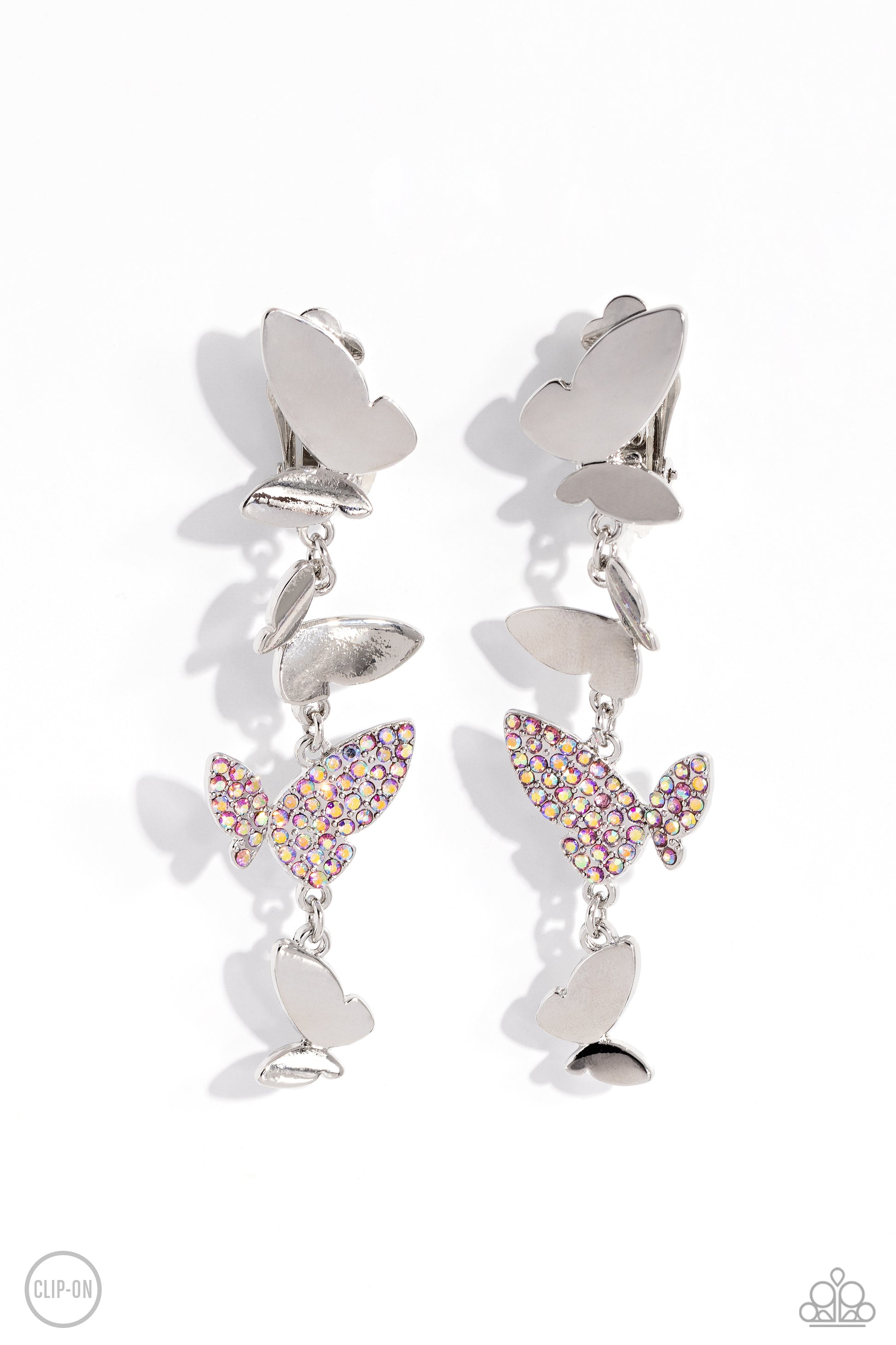 Flying Flashy Pink Butterfly Clip-On Earring - Paparazzi Accessories  Three butterflies with high-sheen silver wings and one pink iridescent-encrusted butterfly flutter down the ear, creating a free-spirited lure. Each butterfly swings in whimsical asymmetry, creating the look of butterflies flying in alternating directions. Earring attaches to a standard clip-on fitting. Due to its prismatic palette, color may vary.  Sold as one pair of clip-on earrings.  P5CO-PKXX-047XX