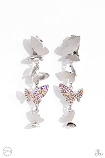 Flying Flashy Pink Butterfly Clip-On Earring - Paparazzi Accessories  Three butterflies with high-sheen silver wings and one pink iridescent-encrusted butterfly flutter down the ear, creating a free-spirited lure. Each butterfly swings in whimsical asymmetry, creating the look of butterflies flying in alternating directions. Earring attaches to a standard clip-on fitting. Due to its prismatic palette, color may vary.  Sold as one pair of clip-on earrings.  P5CO-PKXX-047XX