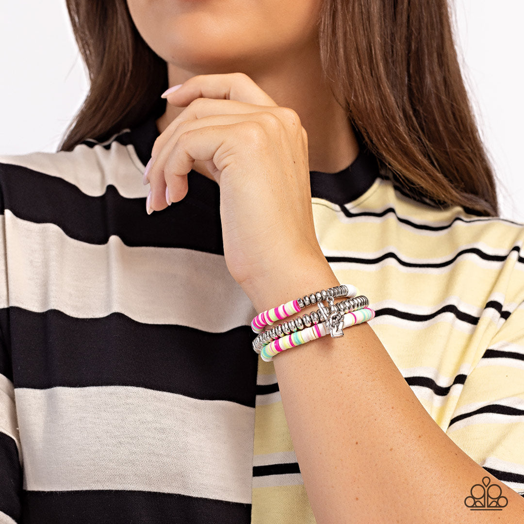 Peaceful Potential White Stretch Bracelet - Paparazzi Accessories  Infused along stretchy bands white, pink, green, blue, and tan rubber discs combine with sporadically placed silver discs and a silver disc strand for a vibrant pop of color along the wrist. A silver peace sign dangles from one of the colorful strands for a youthful finish.  Sold as one set of three bracelets.  P9WH-WTXX-260XX