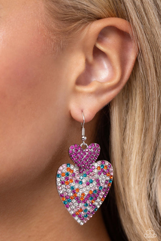 Flirting Flourish Pink Earring - Paparazzi Accessories  Embossed in dainty rhinestones, a fuchsia rhinestone-covered silver heart frame delicately links with a larger silver heart frame featuring fuchsia, light pink, blue, white, and orange rhinestones for a flirtatiously vibrant look. Earring attaches to a standard fishhook fitting.  Sold as one pair of earrings.  New Kit Sku:  P5ST-PKXX-034XX