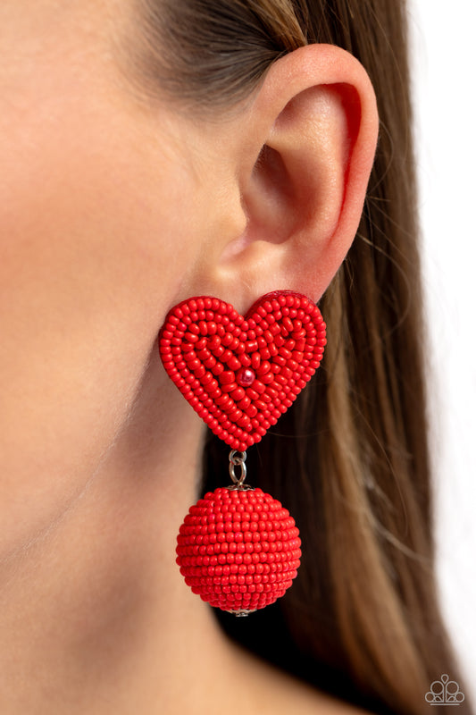 Spherical Sweethearts Red Heart Post Earring - Paparazzi Accessories  Featuring a red pearl center, a red seed bead heart frame gives way to strands of red seed beads that decoratively spin around a spherical frame, resulting in a colorful three-dimensional display. Earring attaches to a standard post fitting.  Sold as one pair of post earrings.  P5PO-RDXX-042XX