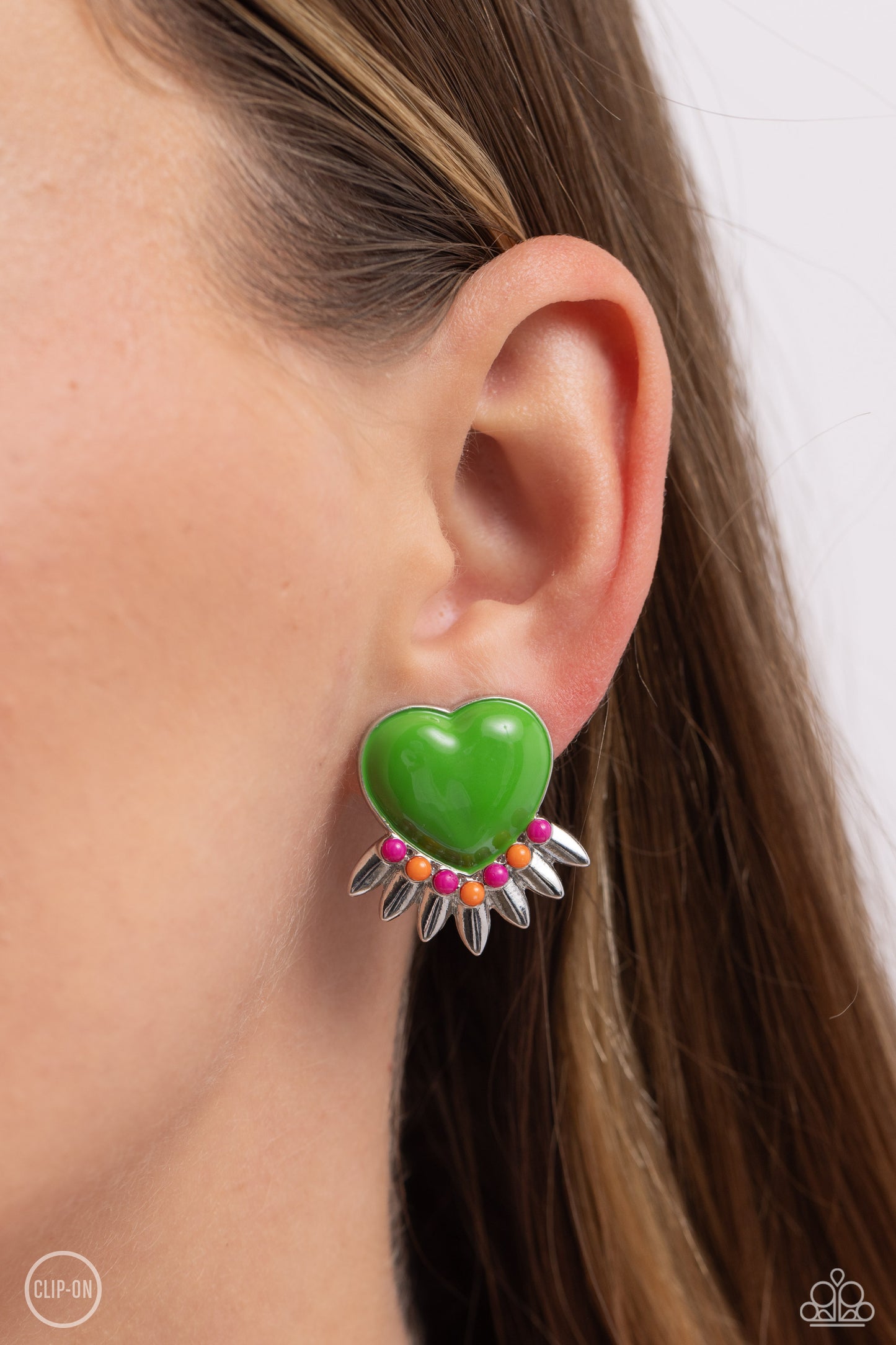 Spring Story Green Heart Clip-On Earring - Paparazzi Accessories  A Classic Green heart pressed in a sleek silver frame stands out at the ear. Textured silver leaves flare out from a curved cluster of Rose Violet and orange seed beads that adorn the bottom of the heart display, creating a spring-inspired fringe. Earring attaches to a standard clip-on fitting.  Sold as one pair of clip-on earrings.  P5CO-GRXX-023XX