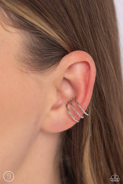 Textured Triumph Silver Cuff Earring - Paparazzi Accessories  Featuring a rope-like texture, a skinny bar of silver attaches to the center of an airy silver cuff to create a glistening, adjustable, one-size-fits-all display.  Sold as one pair of cuff earrings.  New KitEar Cuff Sku:  P5PO-CFSV-254XX