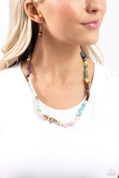 Soothing Stones Multi Necklace - Paparazzi Accessories  Infused on an invisible wire, chiseled turquoise, jade, rose quartz, lapis, amethyst, clear white, gray, and tiger's eye stones coalesce around the collar for a colorfully, earthy statement. White wood beads sporadically dot amongst the chiseled collection for an additional artisanal touch. Features an adjustable clasp closure. As the stone elements in this piece are natural, some color variation is normal.