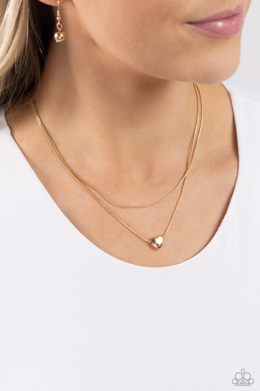 Sweetheart Series Gold Heart Necklace - Paparazzi Accessories  Infused with a dainty gold snake chain, a sleek gold heart charm glides along an additional gold snake chain, creating a stunning layered look. Features an adjustable clasp closure.  Sold as one individual necklace. Includes one pair of matching earrings.  P2DA-GDXX-325XX