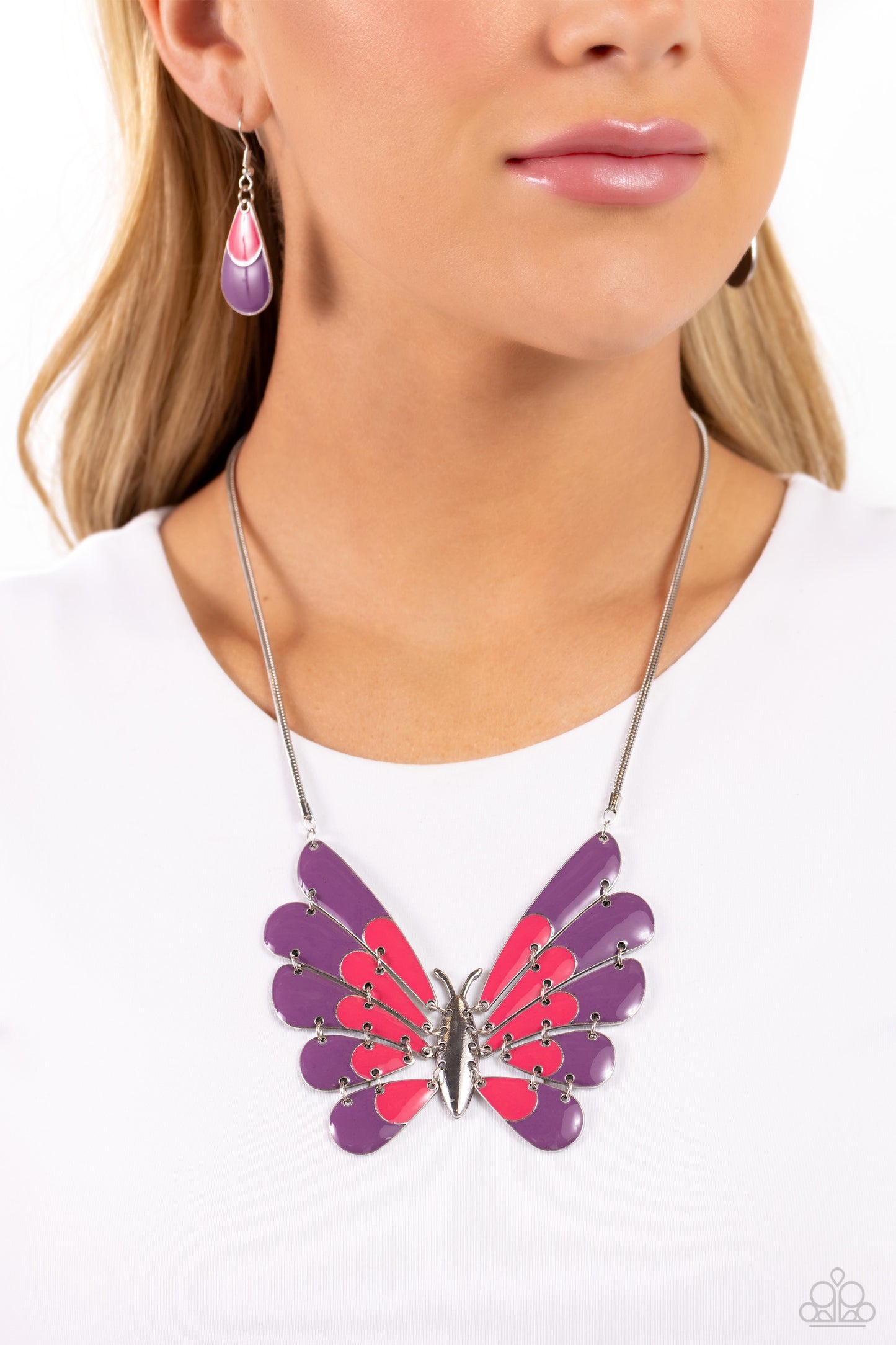 Moth Maven Purple Necklace - Paparazzi Accessories  Featuring hinged wings that gradually decrease in size, an oversized silver moth with Pink Peacock and plum spots of color glides along a sleek silver chain for a whimsical statement. Features an adjustable clasp closure.  Sold as one individual necklace. Includes one pair of matching earrings.  Sku:  P2ST-PRXX-159XX