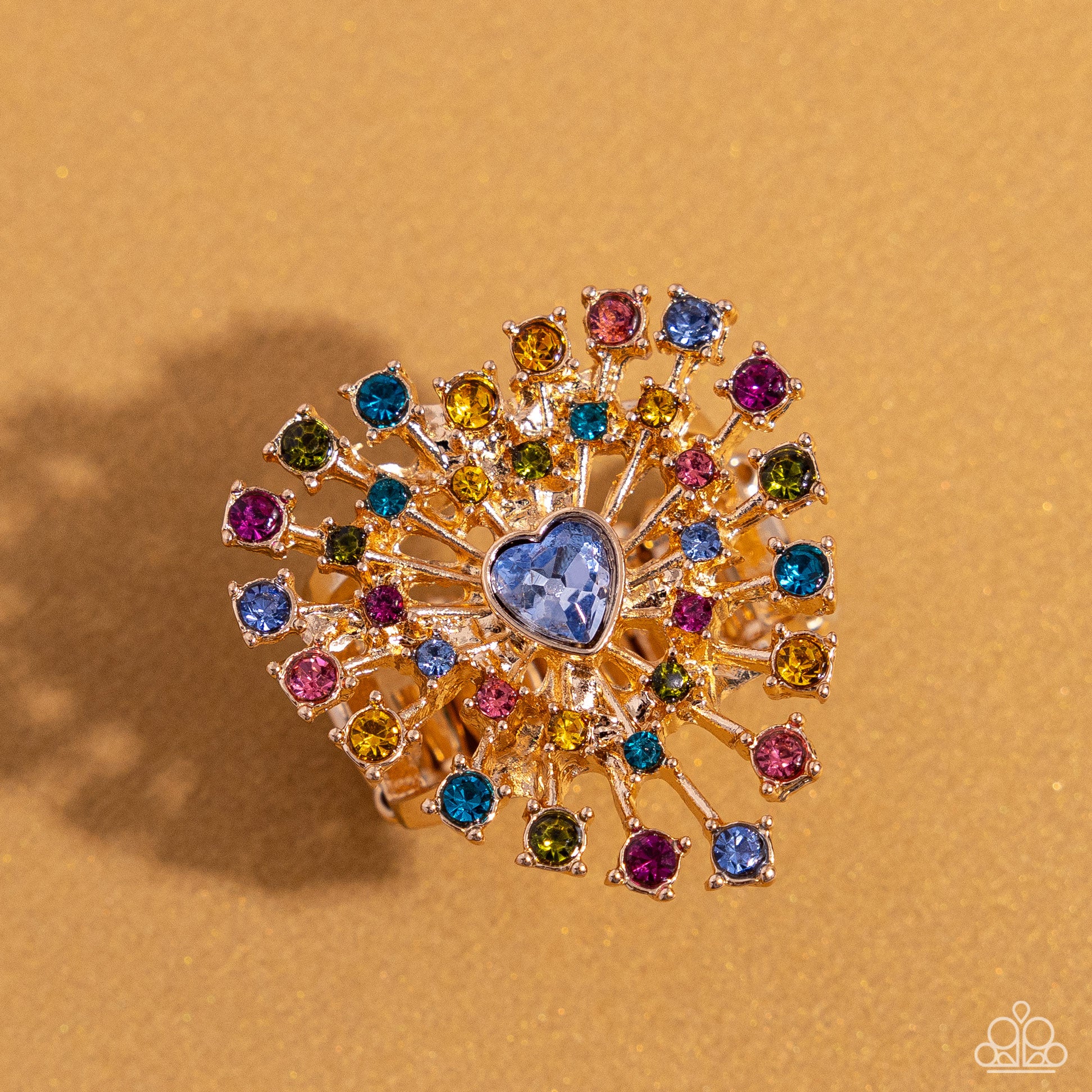 Bewitching Beau Multi Heart Ring - Paparazzi Accessories  Set in pronged gold square fittings, multicolored round rhinestones circle a light sapphire heart gem in a sunburst pattern for a bewitching display. Features a stretchy band for a flexible fit.  Sold as one individual ring.  SKU: P4ST-MTXX-028XX  *LOP January 2024
