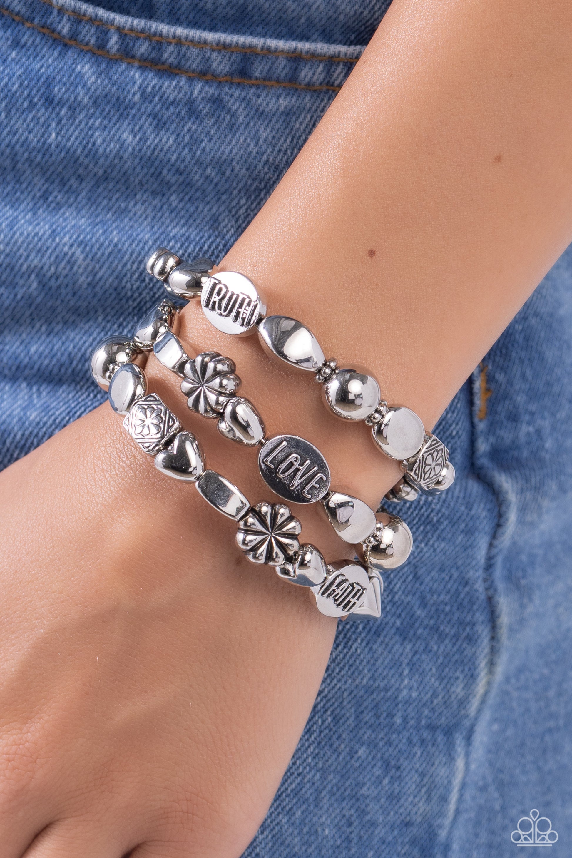 Enchanting Emotion Silver Coil Infinity Wrap Bracelet - Paparazzi Accessories  An enchanting assortment of shiny silver, faceted, and floral embossed beads alternate along a coiled wire, creating a whimsical infinity-style bracelet around the wrist. Additional oval silver beads featuring the words "FAITH," "HOPE," "TRUTH," and "LOVE" finish off the design with an inspirational finish.  Sold as one individual bracelet.  Sku:  P9WD-SVXX-232XX