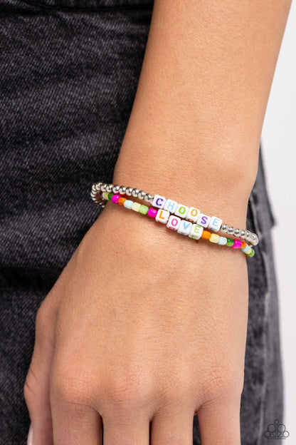 Chasing Love Multi Stretch Bracelet - Paparazzi Accessories  Infused with white cubed beads featuring purple, light blue, Classic Green, orange, and hot pink letters, a mismatched collection of silver and glassy multicolored beads are threaded along stretchy bands. Each multicolored letter on both stacks spells out the words "CHOOSE" and "LOVE", creating two inspirational layers around the wrist.  Sold as one set of two bracelets.  Sku:  P9WD-MTXX-062XX