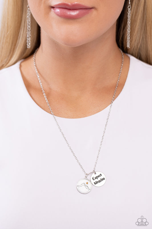 Expect Miracles White Inspirational Necklace - Paparazzi Accessories  Gliding along a glistening silver chain, a silver pendant with the phrase "Expect Miracles" layers next to a silver mountain-outlined pendant with a white-painted cloud atop it. A mustard seed, encased in a clear case over the mountain shape forms a moon for an inspirational finish. Features an adjustable clasp closure.  Sold as one individual necklace. Includes one pair of matching earrings.  P2WD-WTXX-275XX