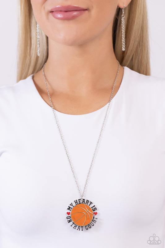Courting Courtside Orange Basketball Necklace - Paparazzi Accessories  Dangling from an extended dainty silver chain, an oversized orange-painted basketball pendant features the phrase "My Heart is on that Court" in all caps and black lettering as it wraps around the ball. Red-painted hearts separate "My heart is" from "on that Court" for a sport-loving-inspired finish. Features an adjustable clasp closure.  Sold as one individual necklace. Includes one pair of matching earrings.  P2WD-OGXX-084XX