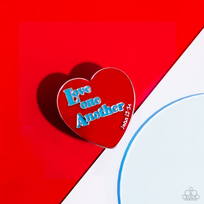As I Have Loved You Red Inspirational Ring - Paparazzi Accessories  Stamped atop an oversized, red-painted heart, the phrase "Love one Another" is featured in a blue hue. The scripture reference, "John 13:34," curves up one side of the red heart frame in silver letters atop airy silver bands for a religious-inspired centerpiece. Features a stretchy band for a flexible fit.  Sold as one individual ring.  Sku:  P4WD-RDXX-064XX
