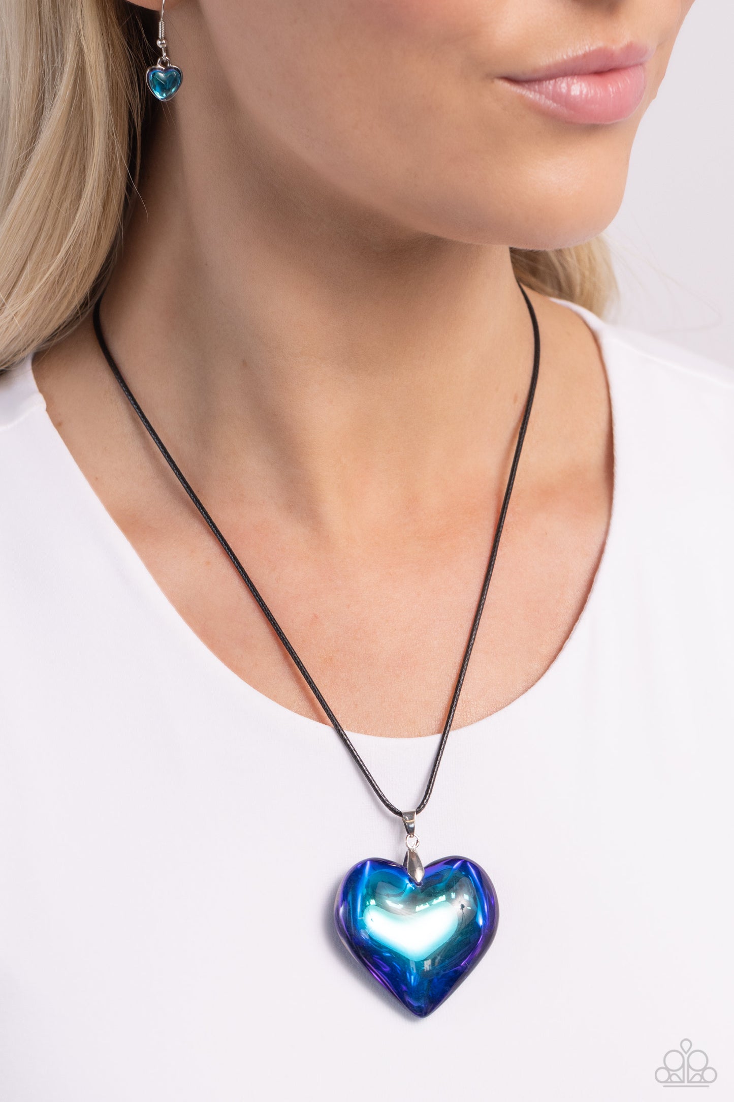 Seize the Simplicity Blue Heart Necklace - Paparazzi Accessories  Wrapped in a blue UV finish, an oversized heart pendant glides along a lengthened strand of black cord across the chest for a stellar flair. Features an adjustable clasp closure.  Sold as one individual necklace. Includes one pair of matching earrings.  Sku:  P2ST-BLXX-229XX