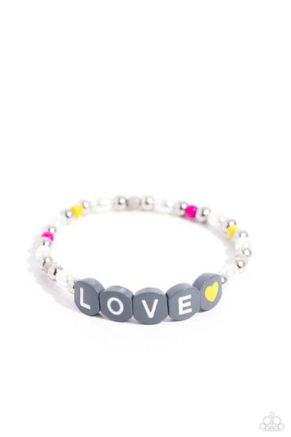 Love Language Silver Stretch Bracelet - Paparazzi Accessories  Infused on an elastic stretchy band, white pearls, gray, hot pink, and yellow seed beads, silver studs, and gray beads spelling out the word "LOVE" with a yellow heart bead aside it wraps around the wrist for a sentimental, youthful display.  Sold as one individual bracelet.  P9WH-SVXX-259XX