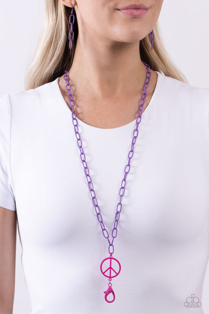 Tranquil Unity Purple Peace Sign Lanyard - Paparazzi Accessories  Featuring a hot pink hue, a peace sign dangles from a purple-painted paperclip chain for a groovy pop of color along the chest. A hot pink lobster clasp hangs from the bottom of the design to allow a name badge or other item to be attached. Features an adjustable clasp closure.  Sold as one individual lanyard. Includes one pair of matching earrings.  Sku:  P2LN-PRXX-025XX