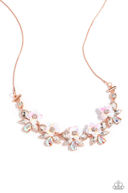 Ethereally Enamored Copper Necklace - Paparazzi Accessories  Pieces of shimmery, iridescent sequins fan out around sparkling white rhinestones to create three-dimensional flowers that bloom along the neckline. White marquise-cut gems and iridescent teardrops flare out behind each floral frame, adding irresistible sparkle to the design. Finally, white rhinestones separate each enchanting cluster, culminating in a dreamy display suspended from a dainty shiny copper snake chain.