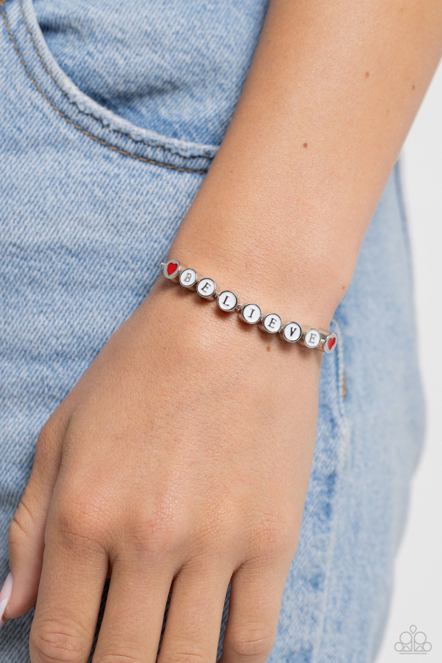 I Cant Believe It! White Sliding Bead Bracelet - Paparazzi Accessories  Delicately attached to a dainty silver box chain, thick circular silver fittings spell out the word "BELIEVE" across a white-painted backdrop with red-painted hearts embellishing the ends of the word, creating a sleek inspiring display. Features an adjustable sliding bead closure.  Sold as one individual bracelet.  Sku:  P9WD-WTXX-141XX
