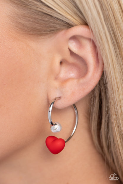 Romantic Representative Red Heart Jacket Earring - Paparazzi Accessories  A solitaire white pearl attaches to a double-sided post, designed to fasten behind the ear. Dotted with a red acrylic heart, the double-sided post peeks out beneath the ear for a romantic look. Earring attaches to a standard post fitting. Hoop measures approximately 1" in diameter.  Sold as one pair of double-sided hoop earrings.  SKU: P5HO-RDXX-030XX
