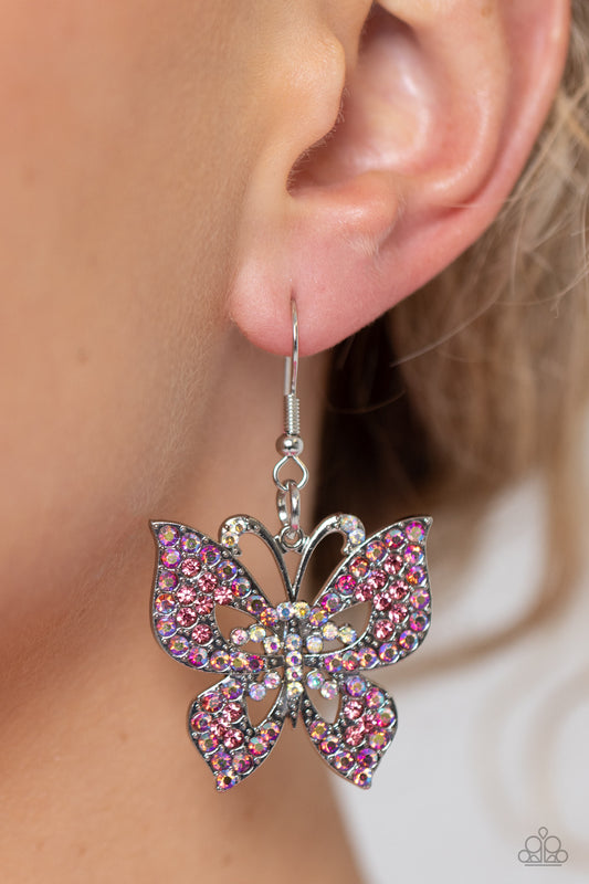 Bejeweled Breeze Pink Butterfly Earring - Paparazzi Accessories  An exaggeratedly oversized, airy silver butterfly is dotted with dainty pink multicolored rhinestones along its expansive wings and iridescent rhinestones along its body and antenna as it flutters below the ear for an enchanting fashion. Due to its prismatic palette, color may vary.  Sold as one pair of earrings.  Sku:  P5WH-PKXX-280TB