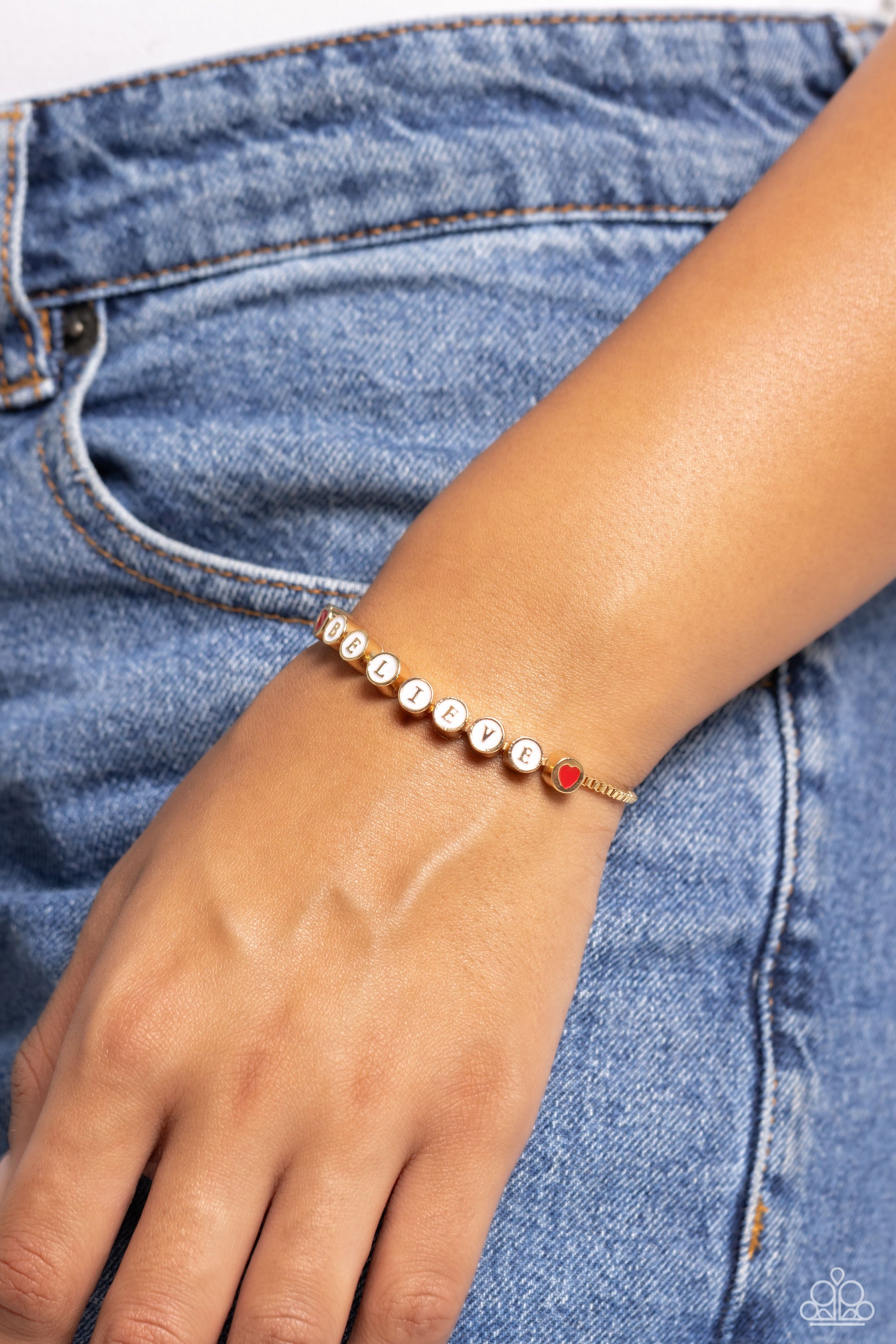 I Cant Believe It! Gold Sliding Bead Bracelet - Paparazzi Accessories  Delicately attached to a dainty gold box chain, thick circular gold fittings spell out the word "BELIEVE" across a white-painted backdrop with red-painted hearts embellishing the ends of the word, creating a sleek inspiring display. Features an adjustable sliding bead closure.  Sold as one individual bracelet.  Sku:  P9WD-GDXX-197XX