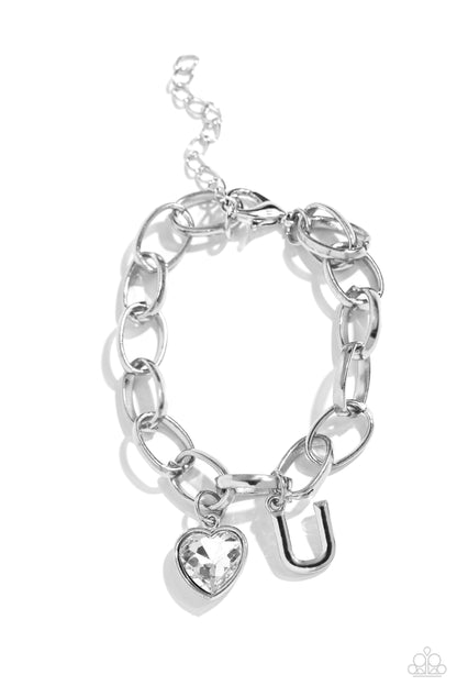 Guess Now Its INITIAL White "U" Bracelet - Paparazzi Accessories  A simple collection of silver charms — including a white rhinestone heart pressed in a silver frame and a sleek letter "U" — dance from a chunky silver chain around the wrist, creating a sentimental fringe. Features an adjustable clasp closure.  Sold as one individual bracelet.  New Kit Sku:  P9BA-WTXX-055XX