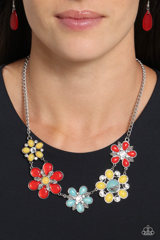 Dragonfly Decadence Red Necklace - Paparazzi Accessories Dotted with white rhinestone and yellow and turquoise beaded centers, a flirtatious assortment of red, yellow, and turquoise flowers link below the collar for a playful pop of color. Textured silver leaves and rhinestone-embellished swirls bloom amongst the petals and from the shimmery centers for additional eye-catching texture. A dainty silver dragonfly charm perches atop one of the flowers for a free-spirited finish. SKU:P2ST-RDXX-130XX