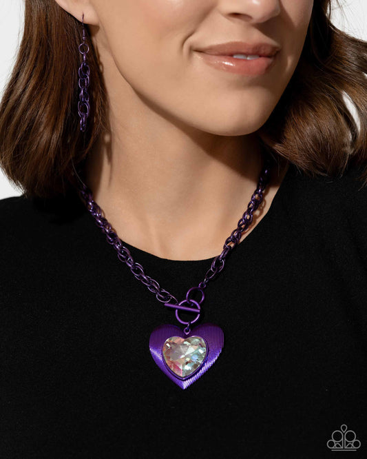 Modern Matchup Purple Heart Necklace (March 2024 LOP) - Paparazzi Accessories  Bordered in linear textures, an oversized white heart gem is pressed into an electric purple heart frame below the collar. The flirtatious pendant attaches to a thick, electric purple chain, resulting in a modern-inspired romance. Features a lariat closure.  Sold as one individual necklace. Includes one pair of matching earrings.  SKU: P2ST-PRXX-166XX