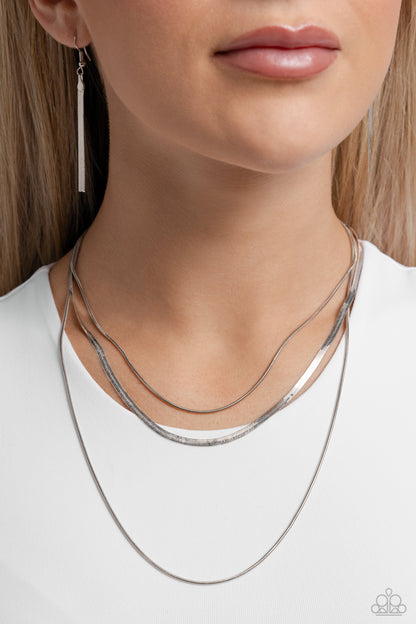 Key LAYER Silver Necklace - Paparazzi Accessories  Two shimmery silver snake chains layer down the chest. A flat silver herringbone chain cascades from the centermost strand for a monochromatic mix-up of texture. Features an adjustable clasp closure.  Sold as one individual necklace. Includes one pair of matching earrings.  SKU: P2RE-SVXX-496XX